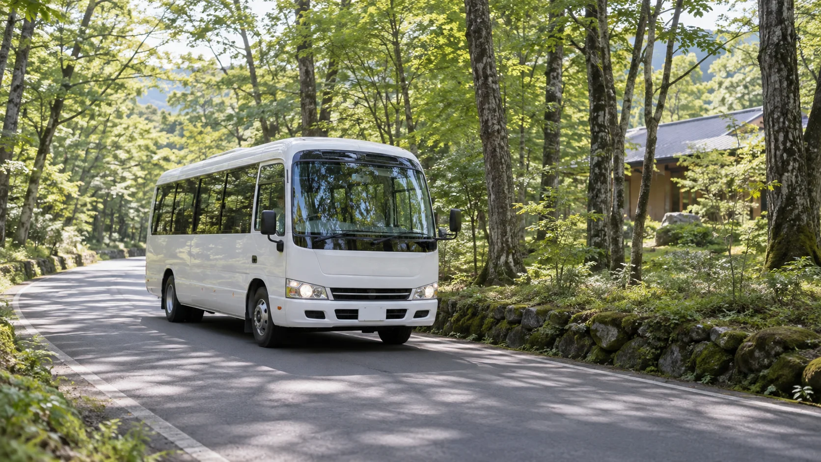 高原のリゾートを走る白いシャトルバスと木立
