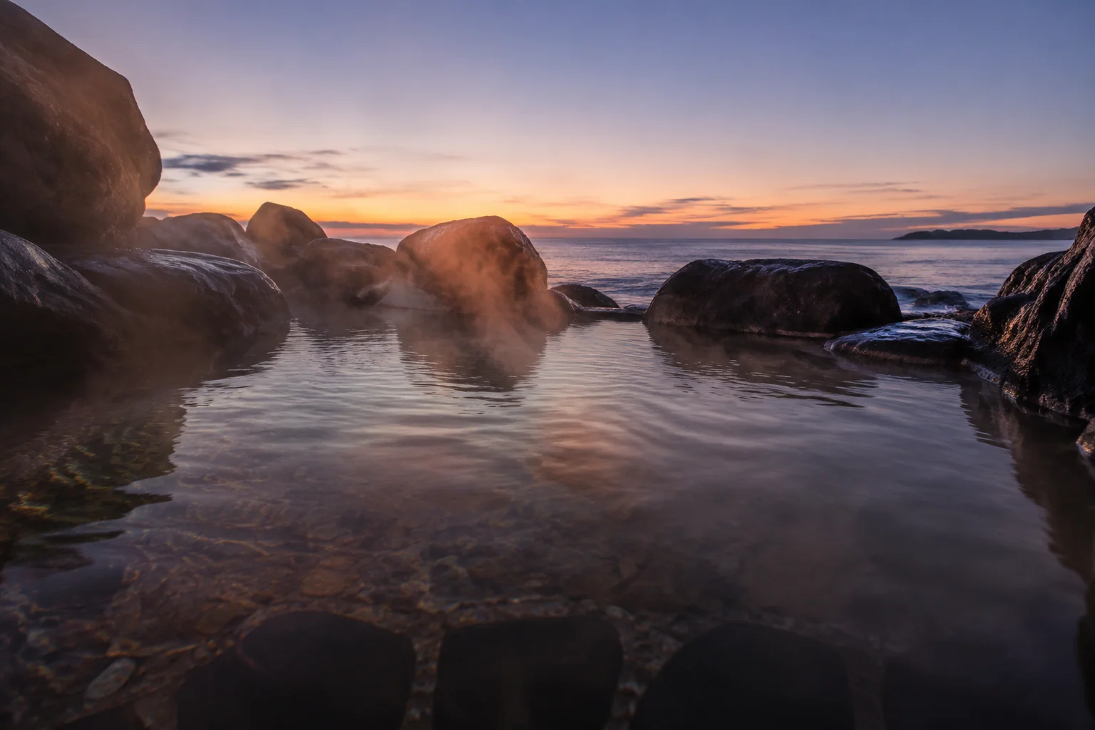 夕暮れの海を望む露天風呂の湯面